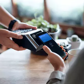 A professional image showcasing a modern point-of-sale terminal and a customer completing a card payment. This visual represents the secure, reliable, and compliant payment solutions offered by Tampa Bay Pay. We help local businesses accept credit cards, debit cards, and contactless payments—with next-day funding, dual pricing options, and personalized support you won’t find from big-box processors.