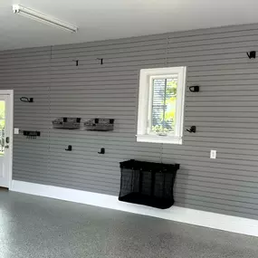 Floor-to-ceiling slatwall is a great way to get bikes and toys off the floor while protecting your drywall from nicks and scratches! Add an epoxy floor, and your garage is transformed!