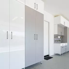 Cabinets aren't always the same color, and that's OK! In addition to a new epoxy floor, this garage includes a two-tone cabinet design to reflect the homeowners unique personal style.