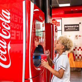 A child makes his drink selection at a Coca-Cola Freestyle machine inside a Five Guys restaurant.