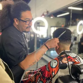 Jimmie at The Neighborhood Barbers with a kids haircut client