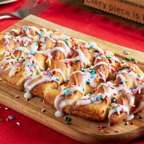 Sweet and delicious pull-apart twists, served warm, drizzled with vanilla icing, and topped with rainbow sprinkles. Serves 4.