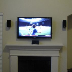 TV with speakers above mantle fire place