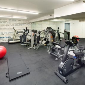Fitness center with cardio equipment, yoga ball, and floor mat