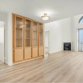 Living area with wood inspired flooring, built in cabinetry and large windows