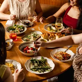 a table filled with food and people enjoying drinks and plates