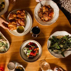 table filled with food: vegetables, wine, and bread