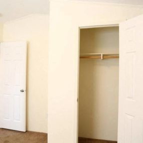 an empty room with a closet and a door open