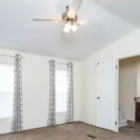 a living room with white walls and a ceiling fan