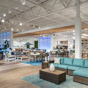 Vibrant patio furniture collection displayed in an open-concept showroom.