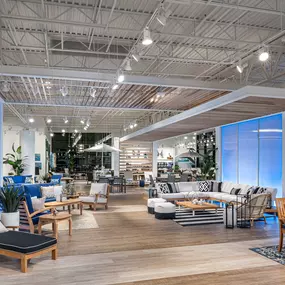 Modern outdoor furniture in a well-lit showroom featuring vibrant blue accents.