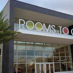 Rooms To Go showroom entrance with iconic logo and glass facade.