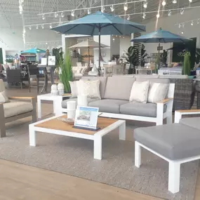 Modern white and wood patio lounge set with light gray cushions and stylish décor.