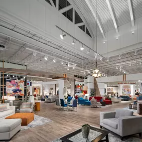 Open-concept showroom at Rooms To Go Pearland, TX, with high ceilings and stylish furniture displays.