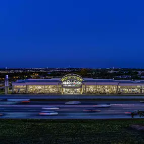 Distant view of the Rooms To Go store at night with highway in the foreground.