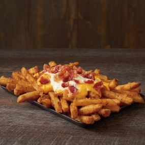 Our Famous Seasoned Fries topped with cheese, ranch and crispy bacon.