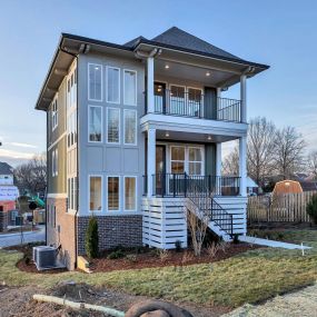 a beautiful new home with a balcony and many windows