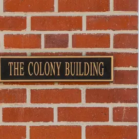 A rectangular, dark metal plaque with the words 