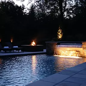 Light your pool up at night with a fire pit, tiki torches and spa spillover lighting