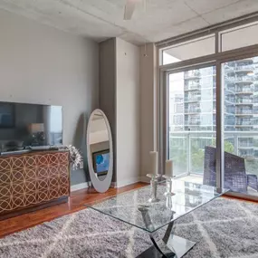 Open concept living room with hardwood floors and balcony access.