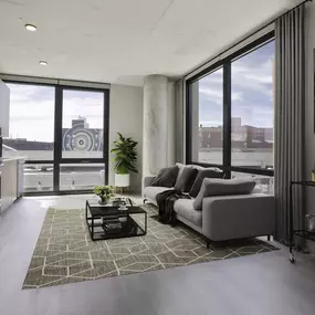 a living room with a couch and a coffee table in front of a window