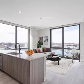 a kitchen with an island and a living room with a couch and a tv