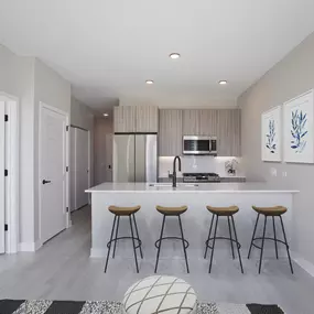 a kitchen with a large island with three stools in front of it