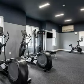 a gym with cardio equipment and weights in a building