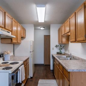 a kitchen with wood cabinets and white appliances and a counter top