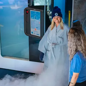 A woman exiting a Restore Cryotherapy chamber