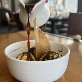 Affogato Dessert featuring vanilla bean gelato encrusted with pistachios, baileys dark chocolate and drizzled with fresh brewed espresso.