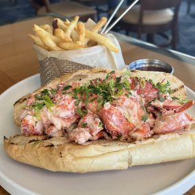 Maine Lobster Roll Sandwich featuring lobster claw meat, celery, lemon and aioli on a Brioche roll.  Served with French fried.