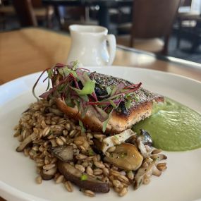 Crispy Skin Salmon featuring a wild mushroom Farro grain medley and English pea jalapeno nage.