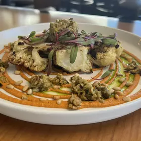 Za'Tar Spice Cauliflower Steak served with Romesco sauce, toasted pine nuts, basil oil and a green olive tapenade.