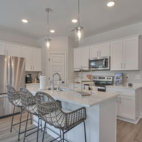 Spacious kitchen with granite countertops including kitchen island and stainless steel appliances.