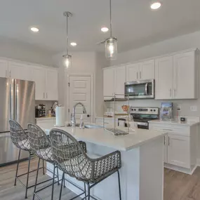 Spacious kitchen with granite countertops including kitchen island and stainless steel appliances.