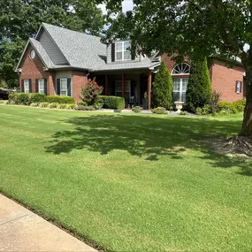 Fairway Lawns maintains a lush, green lawn around this two-story brick and stone home, showcasing their expert care and attention to detail.