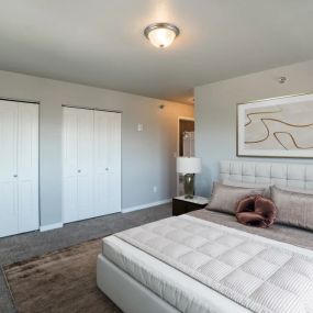 bedroom with a large white bed and white closets.