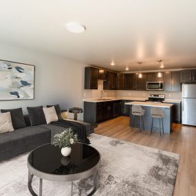 living room with a couch and a table in front of a kitchen