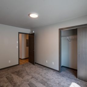 An empty room with a closet and a door to a wardrobe