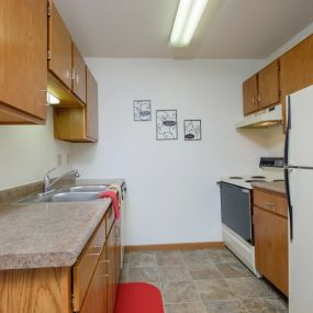 kitchen with wooden cabinets and a sink and a refrigerator.