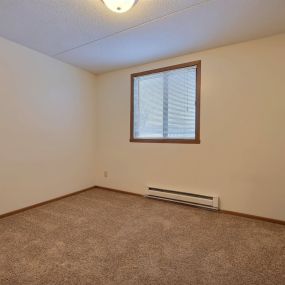 an empty room with a ceiling fan and a window