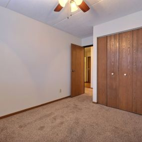 a bedroom with a closet and a door to a hallway