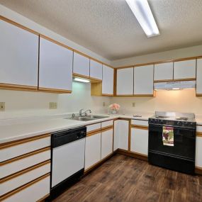 a kitchen with white cabinets and black appliances