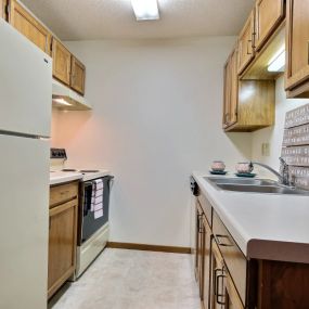 a kitchen with white appliances and wooden cabinets