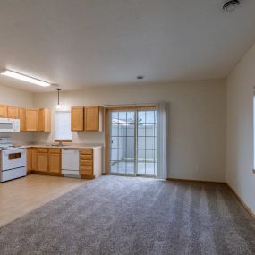 a kitchen and living room with a window and sliding glass door