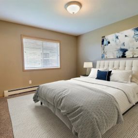 a bedroom with a bed and a painting on the wall