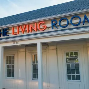 The Living Room Dispensary in Maryland – exterior view of the cannabis dispensary with a bold blue and orange logo sign above the entrance.