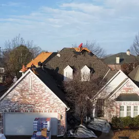 Tearing off the old to make room for a brand new GAF roofing system on this beautiful house.