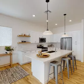 a kitchen with a large island with bar stools